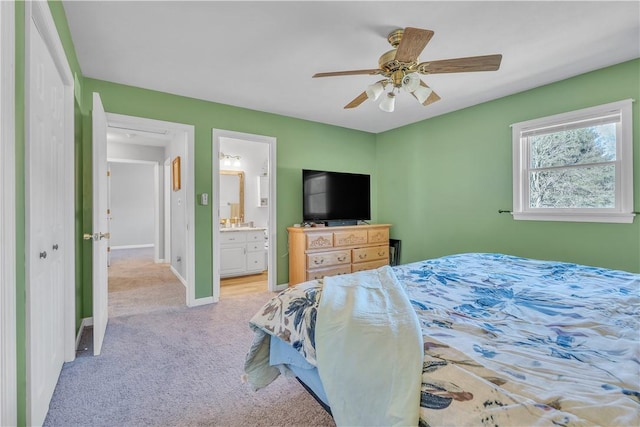 bedroom with light carpet, connected bathroom, a ceiling fan, and baseboards