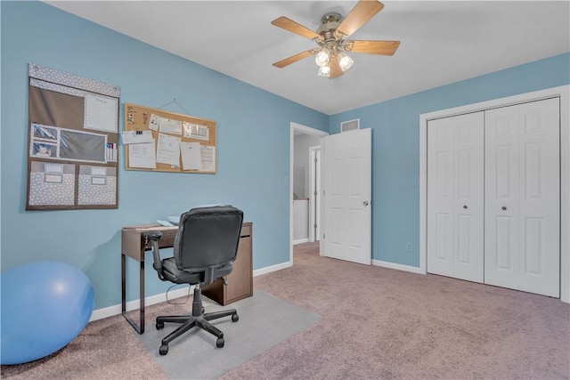 carpeted office featuring visible vents, baseboards, and ceiling fan