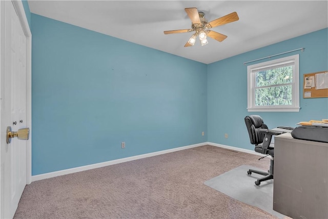 office space featuring carpet flooring, a ceiling fan, and baseboards