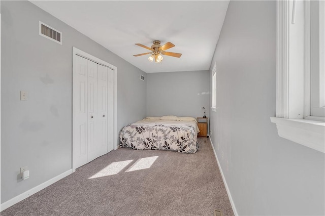 bedroom with carpet, visible vents, a closet, and baseboards