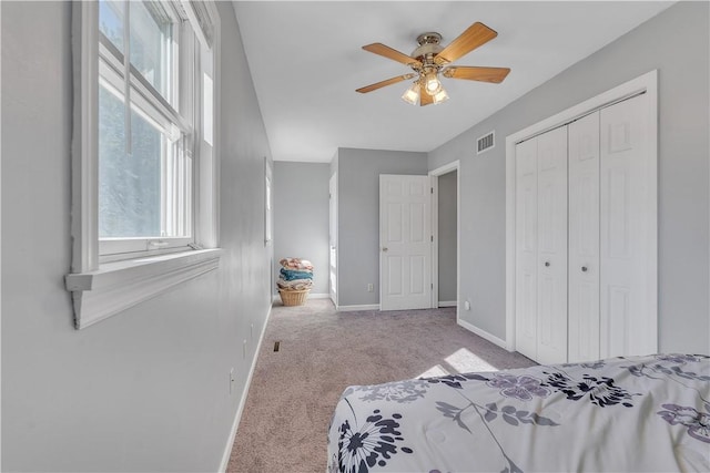 unfurnished bedroom with a ceiling fan, carpet, visible vents, baseboards, and a closet