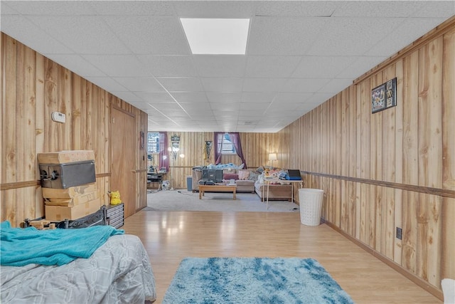 bedroom featuring wood finished floors and wood walls