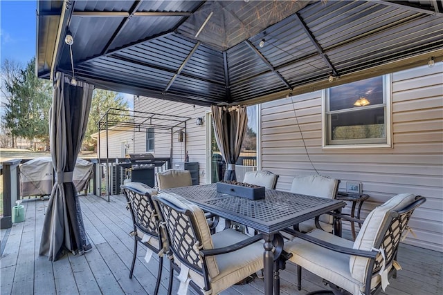 deck featuring outdoor dining space and a gazebo