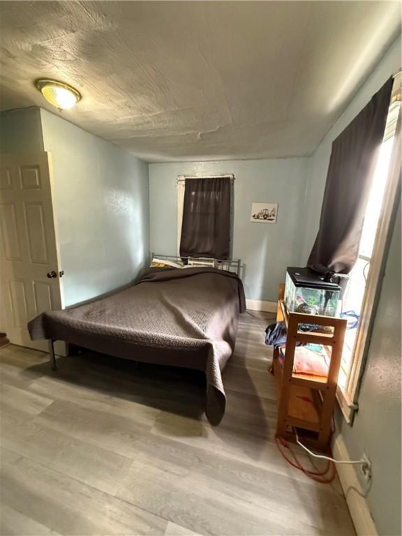 bedroom with baseboards and wood finished floors