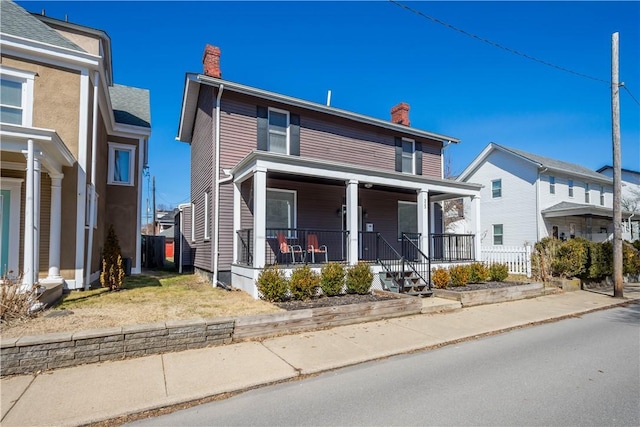 view of front of property with a porch and a chimney