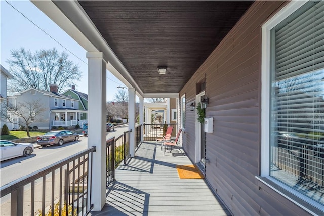 wooden deck with a residential view and covered porch