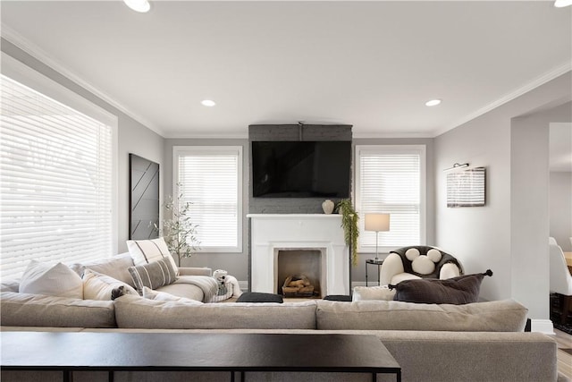 living room featuring a fireplace, recessed lighting, a healthy amount of sunlight, and ornamental molding