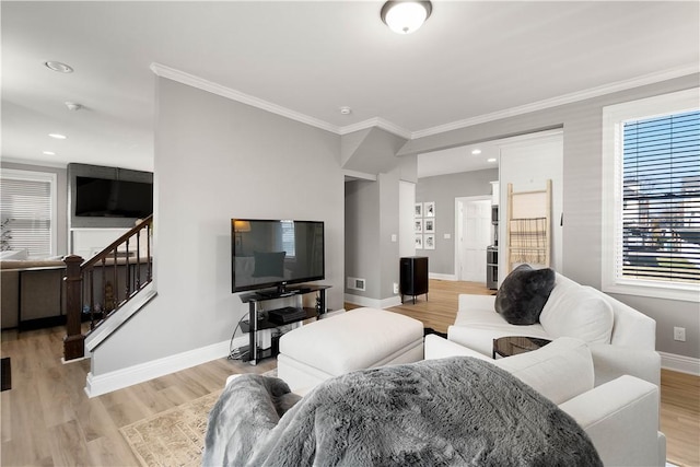 living room with light wood finished floors, stairway, baseboards, and ornamental molding