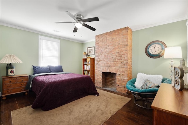 bedroom featuring visible vents, ornamental molding, a brick fireplace, and wood finished floors