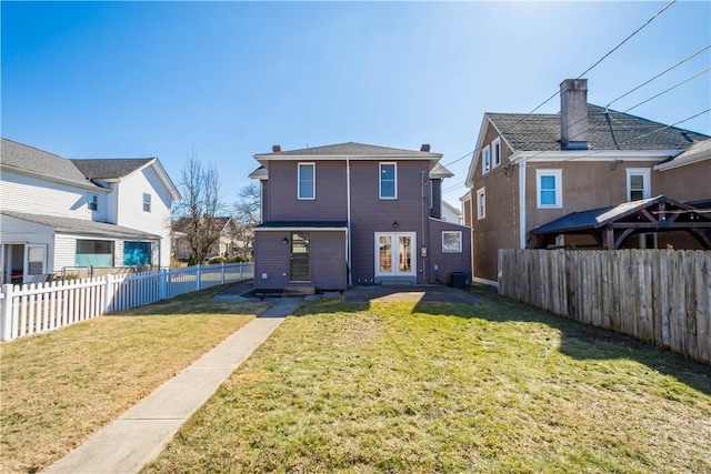 rear view of property with a yard, central AC, a fenced backyard, and french doors