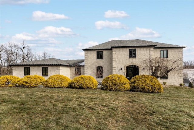 view of front of property featuring brick siding and a front yard