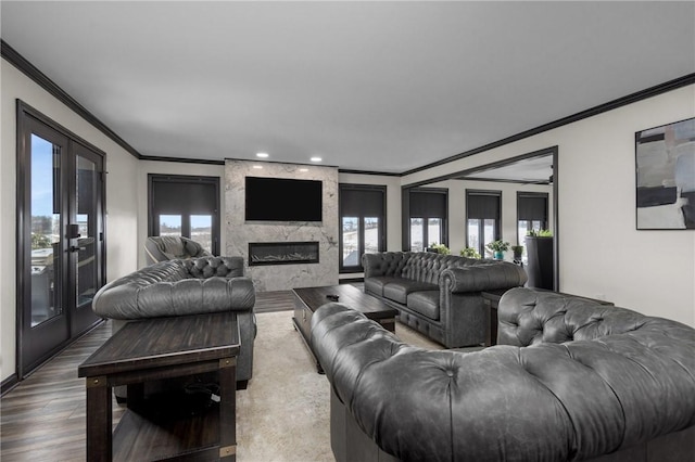 living area featuring french doors, a premium fireplace, dark wood-style flooring, and crown molding