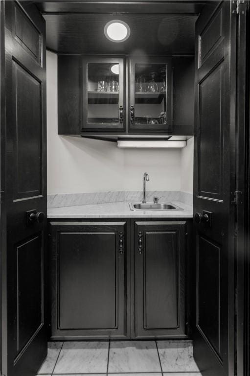 kitchen with a sink, dark cabinetry, and light countertops