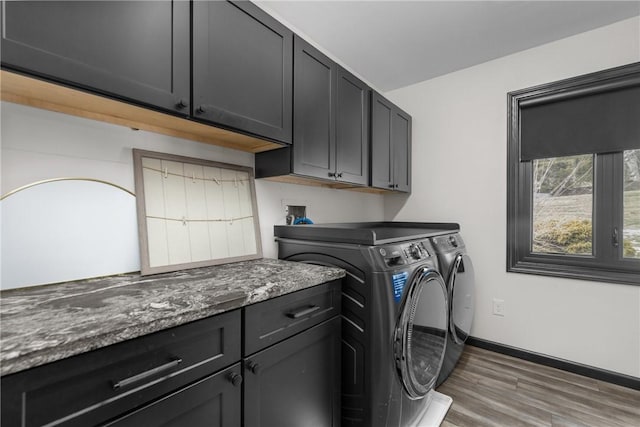 laundry room featuring baseboards, cabinet space, independent washer and dryer, and wood finished floors