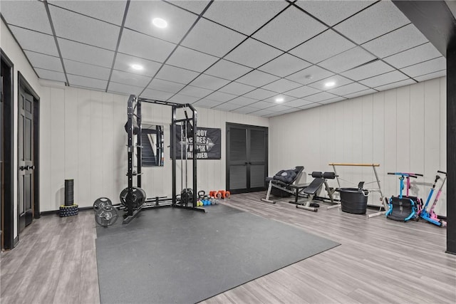 exercise area with recessed lighting, a paneled ceiling, and wood finished floors