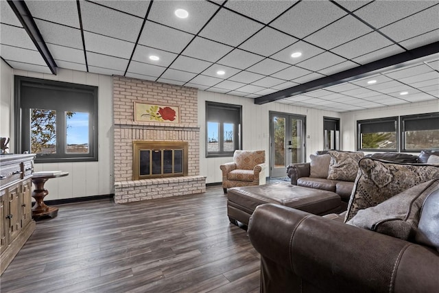 living area with dark wood-style floors, a fireplace, french doors, and a paneled ceiling