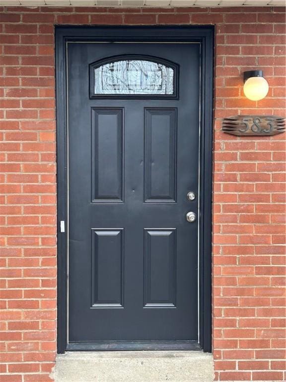 doorway to property featuring brick siding