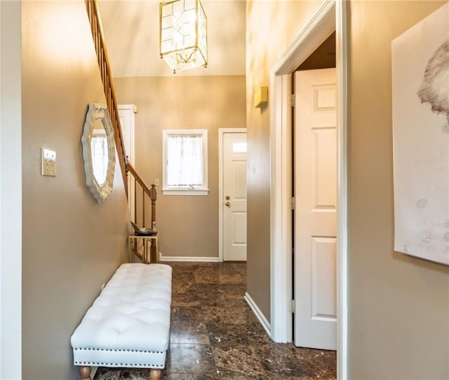 foyer featuring stairway, stone finish floor, and baseboards