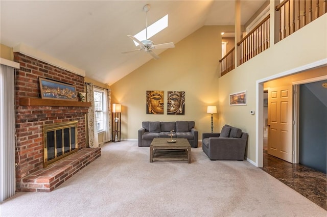 carpeted living area featuring high vaulted ceiling, a skylight, a fireplace, baseboards, and ceiling fan