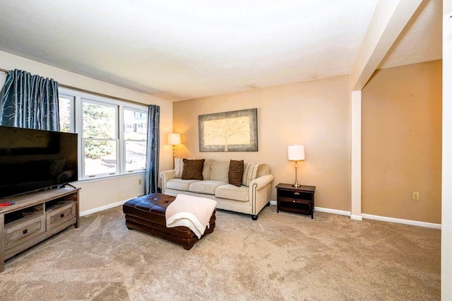 living area featuring carpet and baseboards