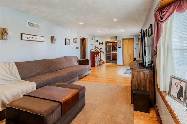 living area with stairs, recessed lighting, visible vents, and light wood-type flooring