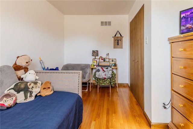 bedroom with light wood-style flooring and visible vents