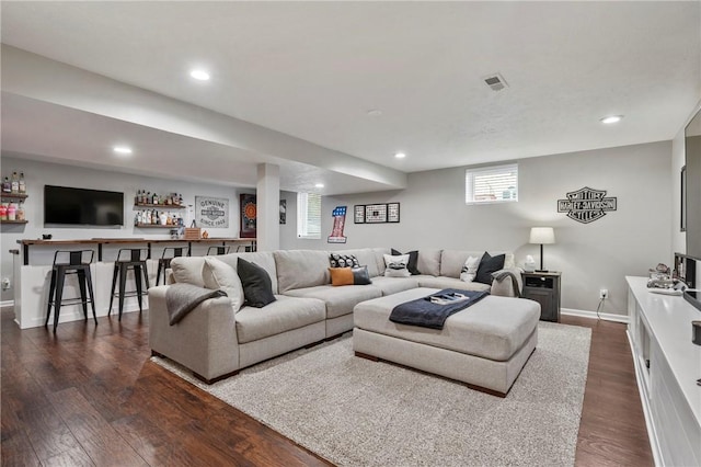 living area featuring visible vents, recessed lighting, a bar, and dark wood-style flooring