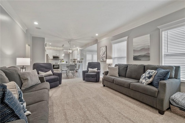 living area with recessed lighting and ornamental molding