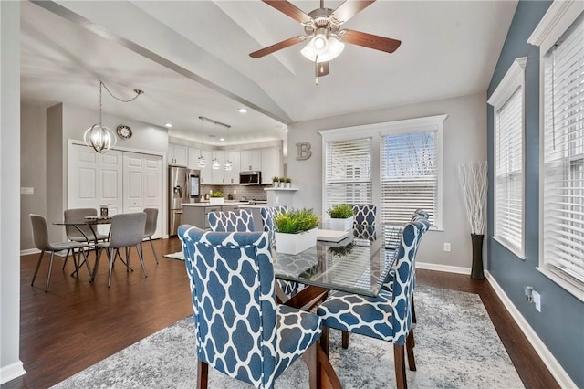 dining area featuring baseboards, ceiling fan with notable chandelier, dark wood-style floors, and vaulted ceiling