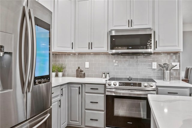 kitchen featuring decorative backsplash, white cabinets, and stainless steel appliances