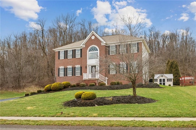 view of front of property featuring a front yard and brick siding