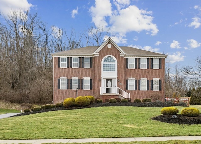 view of front of home featuring a front lawn and brick siding