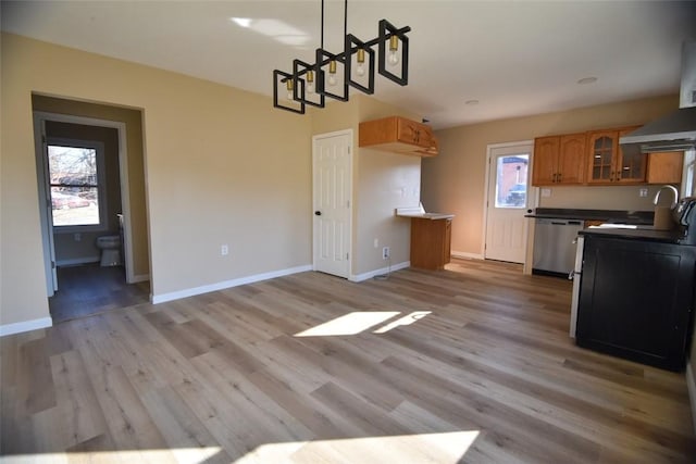 kitchen featuring brown cabinets, a sink, light wood finished floors, glass insert cabinets, and dishwasher