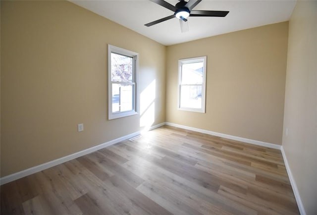 unfurnished room with baseboards, wood finished floors, and a ceiling fan