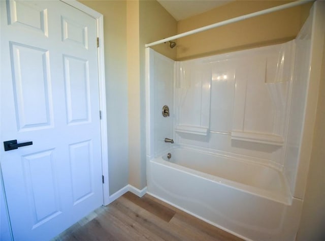 full bath featuring bathtub / shower combination, wood finished floors, and baseboards