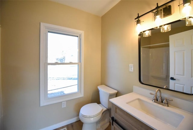 bathroom featuring vanity, toilet, a shower, and baseboards