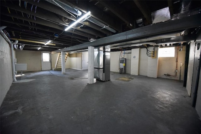 below grade area featuring water heater, heating unit, stairs, and a sink