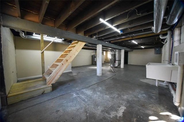 unfinished basement featuring a sink, heating unit, electric panel, and water heater