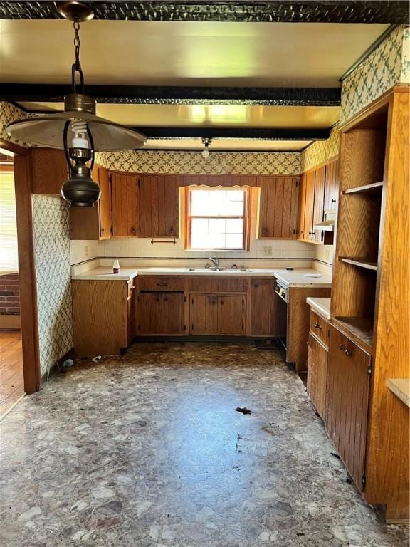 kitchen featuring a sink, open shelves, brown cabinets, and light countertops