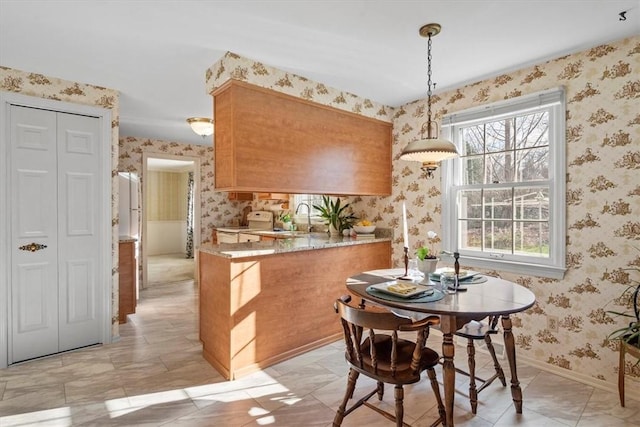 dining space featuring wallpapered walls and baseboards