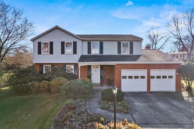 view of front facade featuring brick siding, an attached garage, driveway, and a front yard