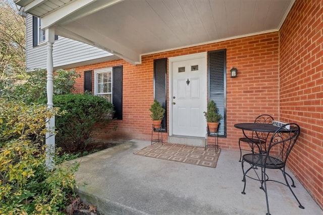 view of exterior entry with brick siding