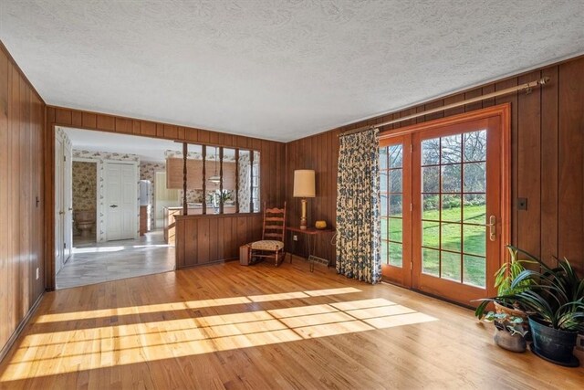 interior space with wood finished floors, a wealth of natural light, and a textured ceiling