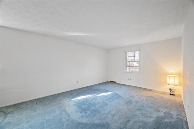 empty room with a textured ceiling and carpet