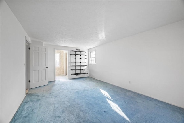 carpeted spare room featuring visible vents