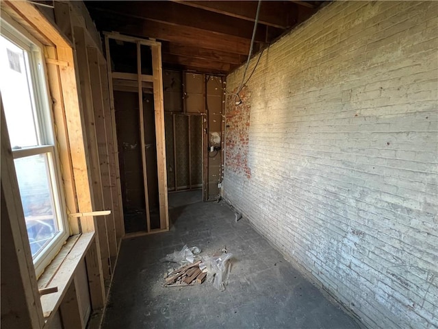 hallway featuring brick wall