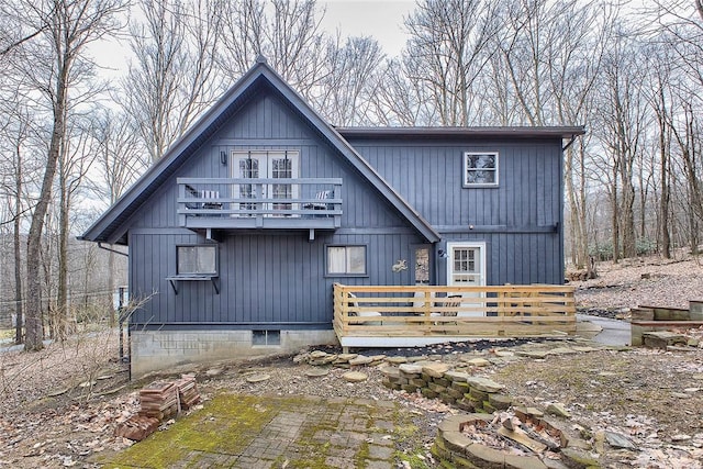 back of house featuring a balcony and a deck