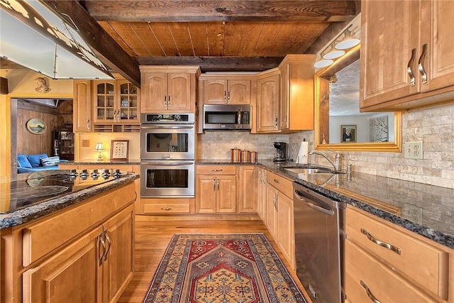 kitchen featuring backsplash, glass insert cabinets, appliances with stainless steel finishes, wooden ceiling, and a sink