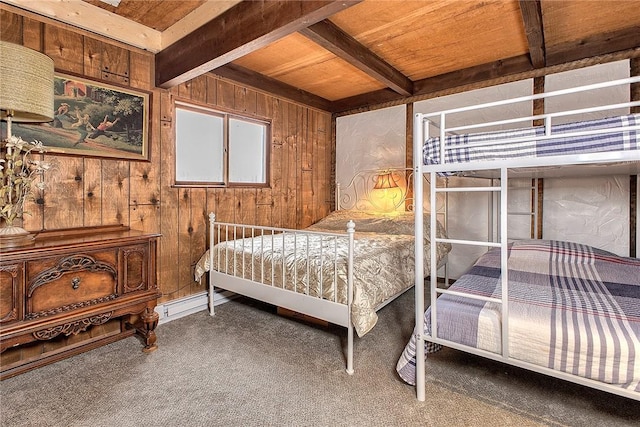 carpeted bedroom with beamed ceiling and wood walls