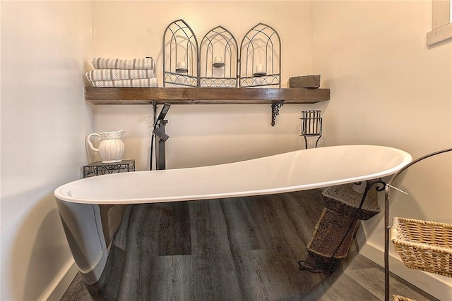 room details featuring wood finished floors, baseboards, and a freestanding tub